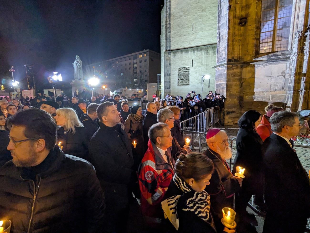 Menschen mit Kerzen vor der Johanniskirche Magdeburg