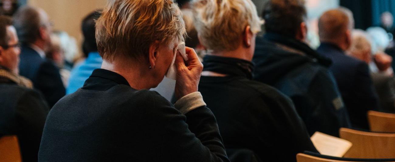 Eine Frau wischt sich Tränen aus den Augen