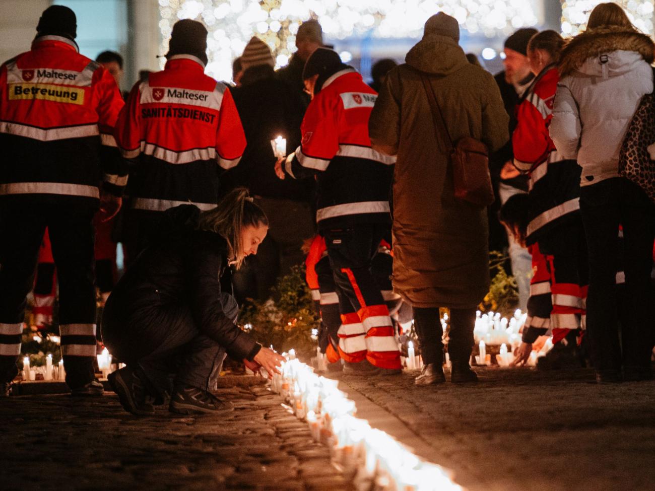 Menschen stellen Kerzen auf