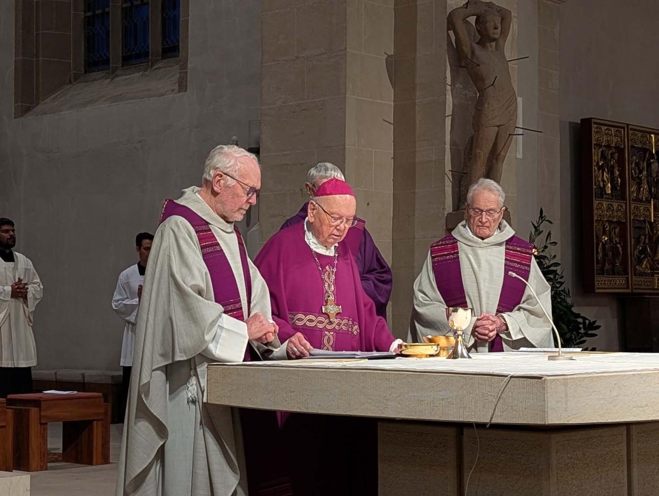 Männer stehen um den Altar