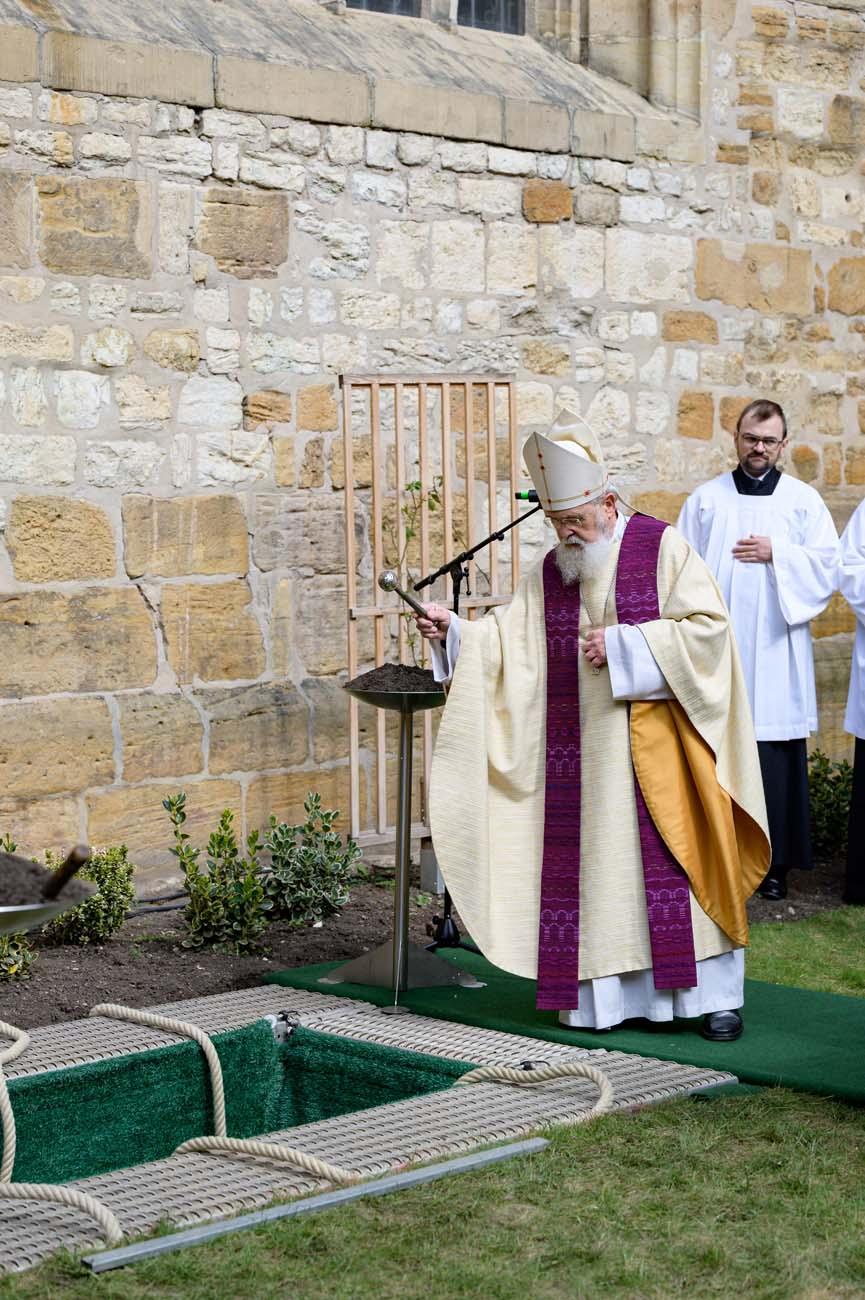 Bischof Feige am offenen Grab