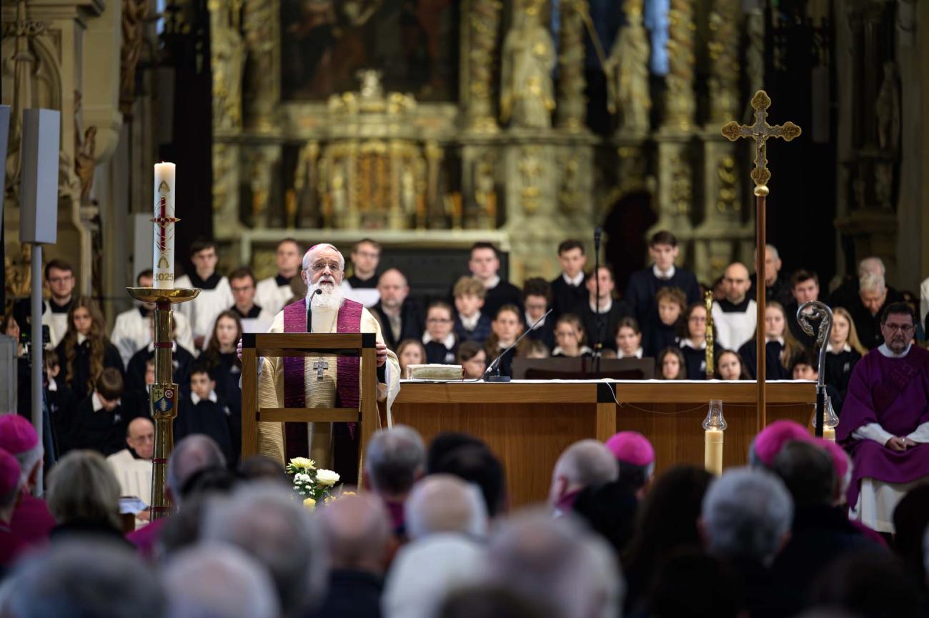 Bischof Feige am Ambo, hinter ihm Ministrantinnen und Ministranten, die Gemeinde im Vordergrund