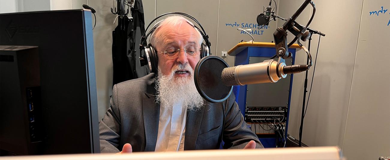 Ein Mann vor einem Mikrofon mit Kopfhörern