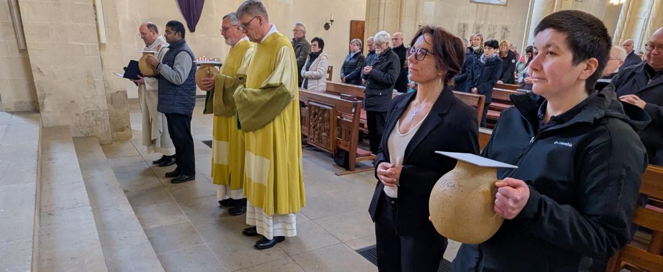 Menschen halten Ölkrüge in einer Kirche
