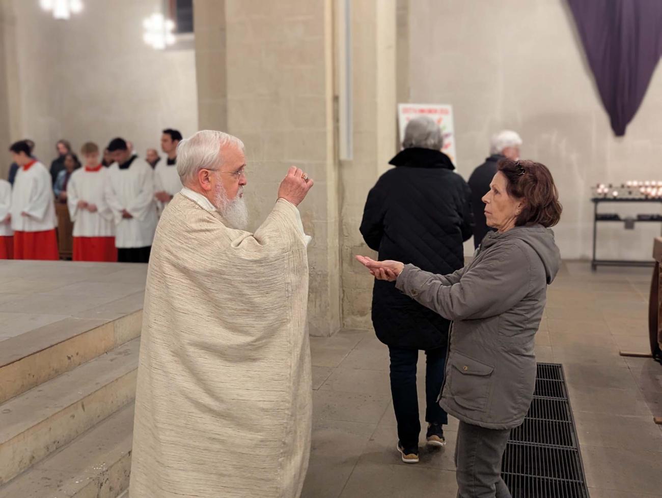 ischof Feige teilt die Kommunion aus