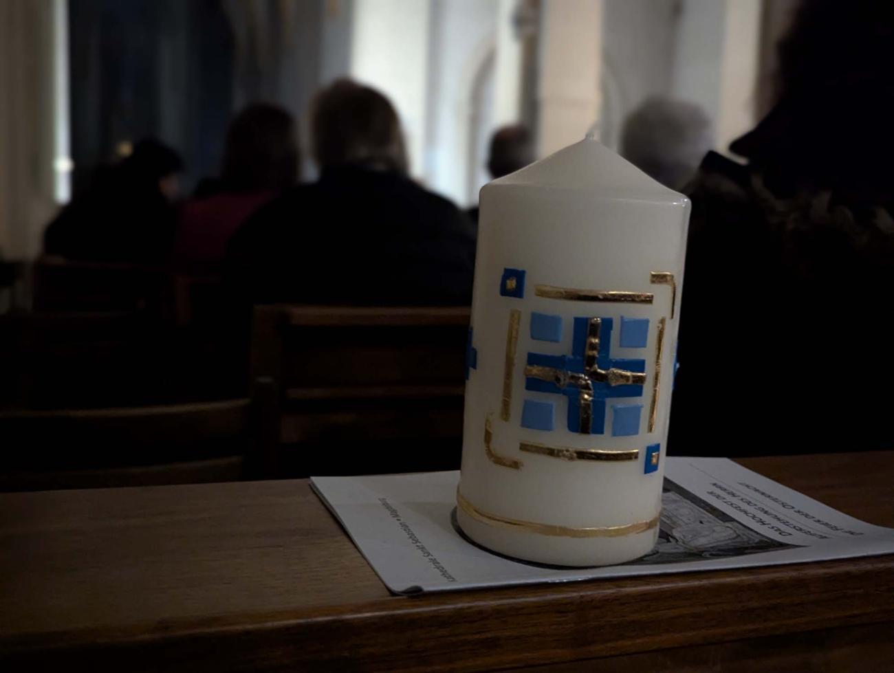 Eine Kerze in einer dunklen Kirche