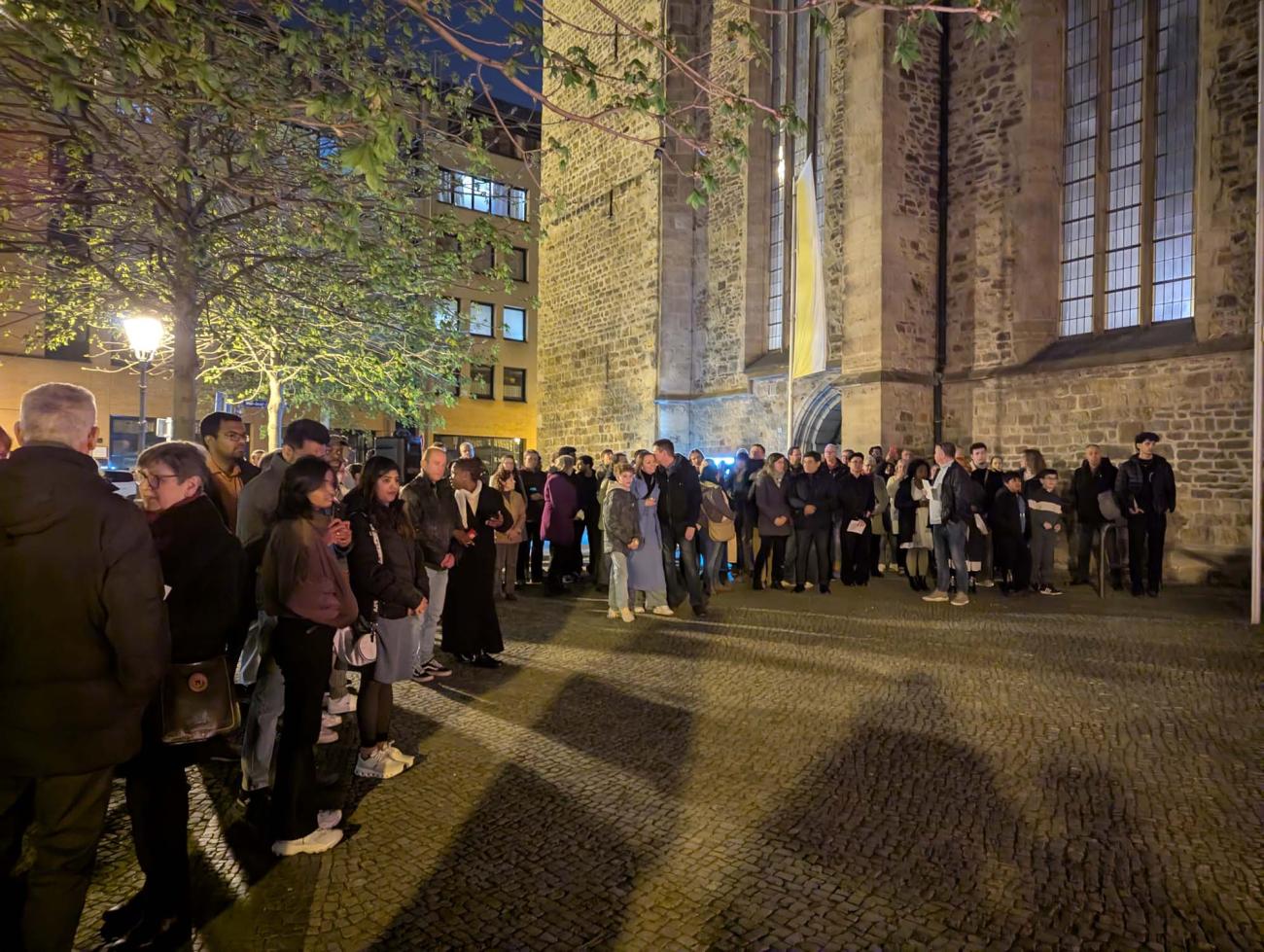 Menschen am Feuer vor einer Kirche