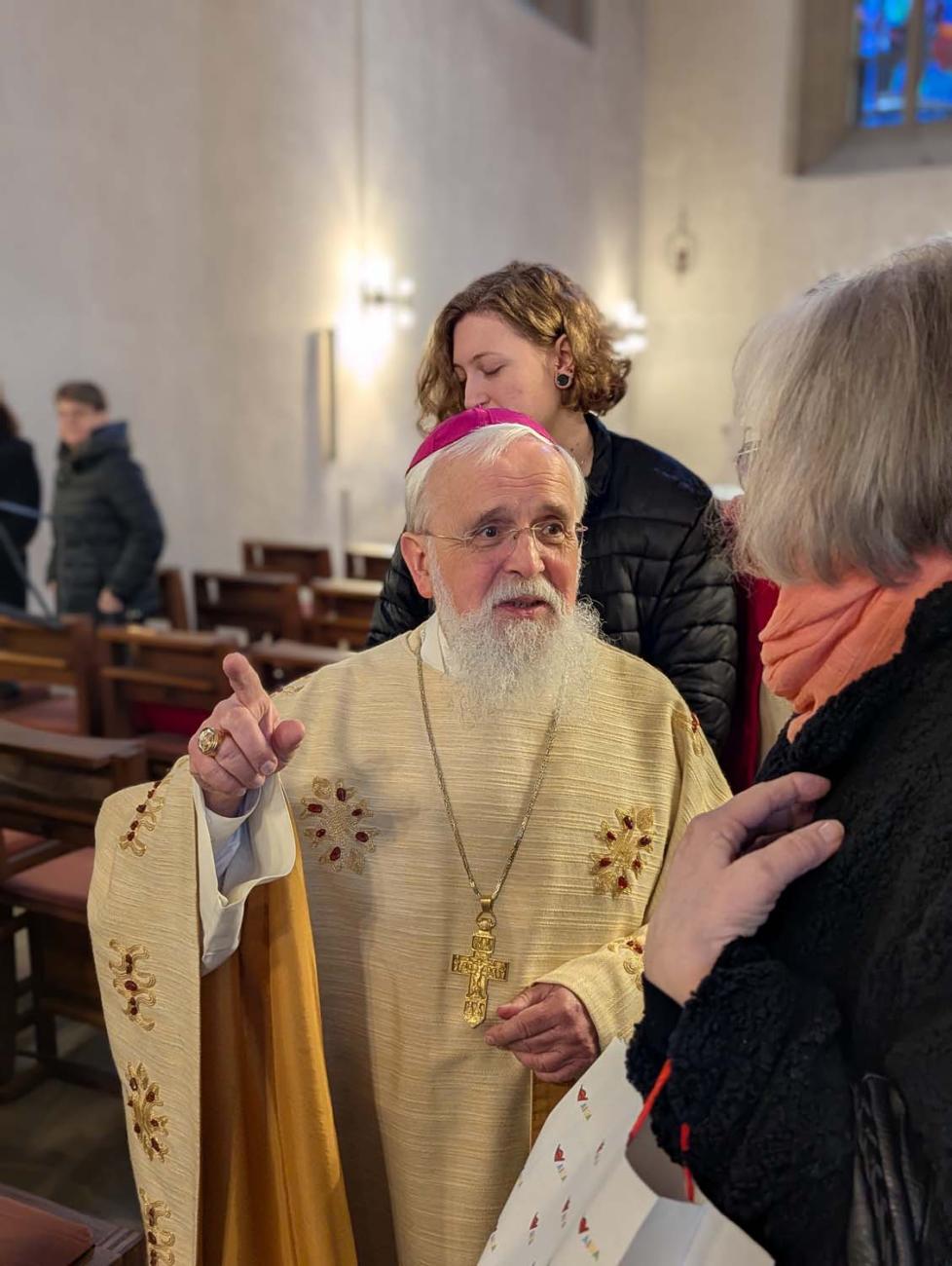 Bischof Feige im Gespräch mit einer Frau 