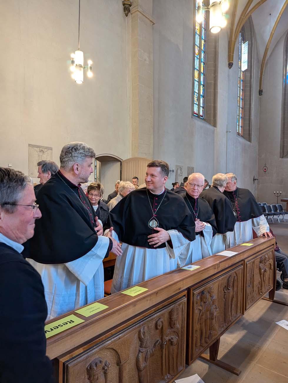 Priester reichen sich die Hand