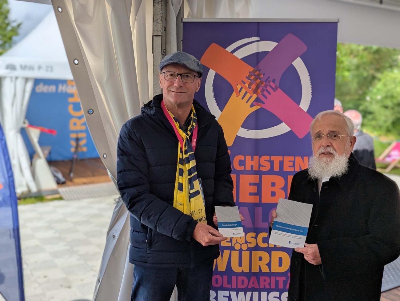 Zwei Menschen mit einem Flyer in der Hand