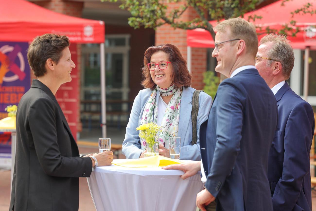 Menschen stehen um einen Tisch
