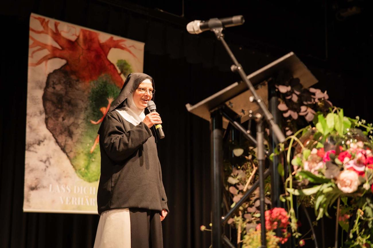 Eine Nonne redet auf einer Bühne