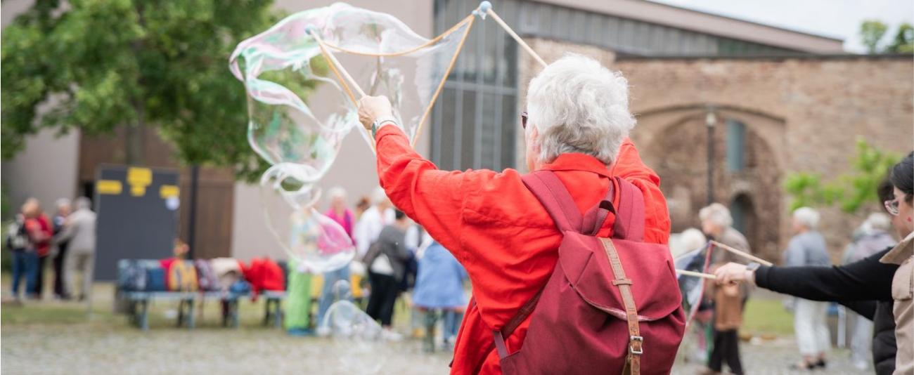 Eine Frau lässt eine Riesenseifenblase entstehen