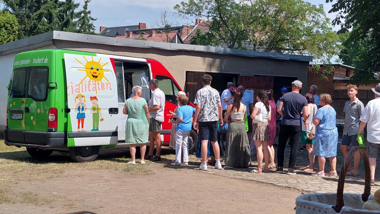 Eine Gruppe Menschen steht an einem Essenswagen an