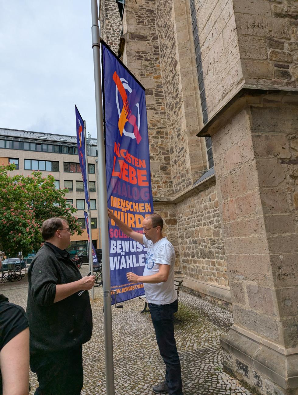 Zwei Männer hissen eine Fahne