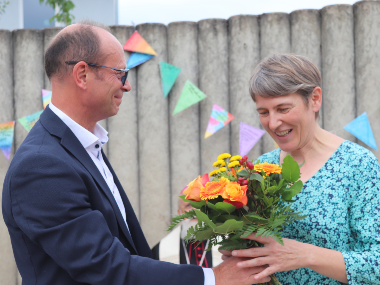 Ein Mann überreicht einer Frau einen Blumeenstrauß