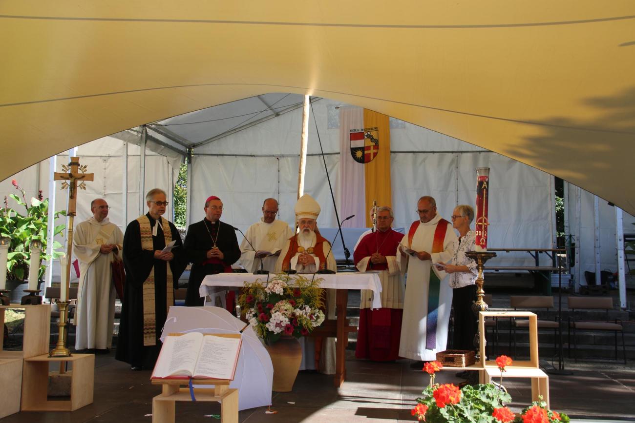 Männer stehen um einen Altar
