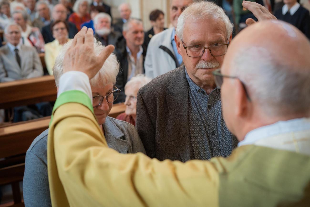 Ein Mann segnet ein Ehepaar