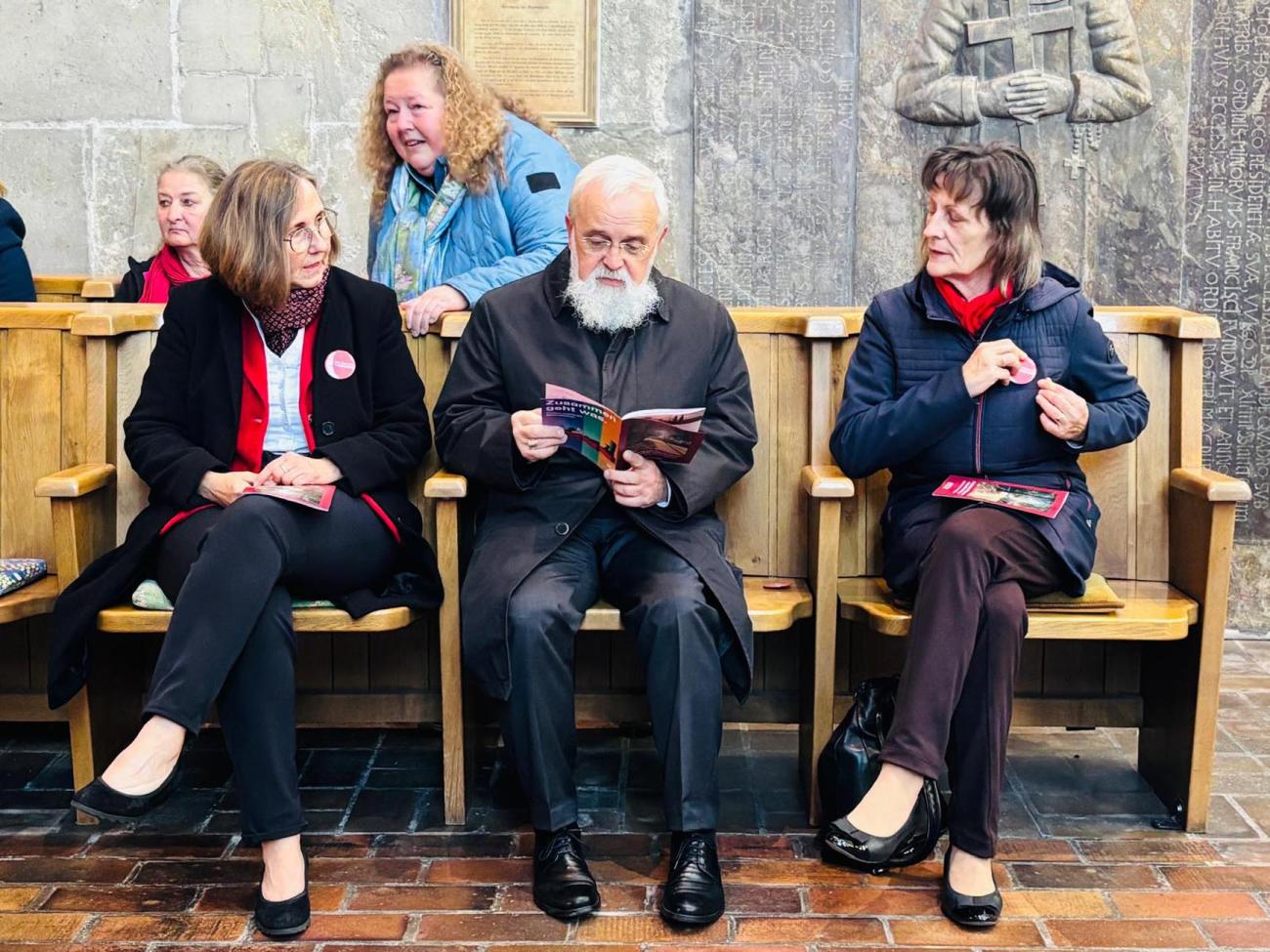 Drei Personen sitzen nebeneinander