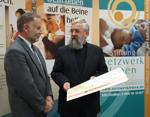 Bischof nimmt den Spendenscheck entgegen
