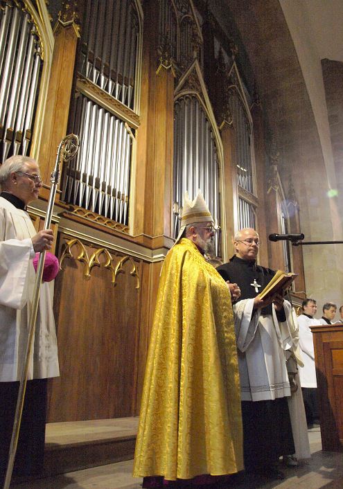 Bischof spricht vor der Orgel das Segensgebet