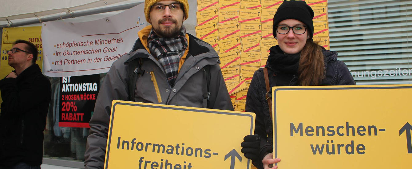 Jugendliche halten wesentliche Werte des GGes auf Schildern in die Kamera.