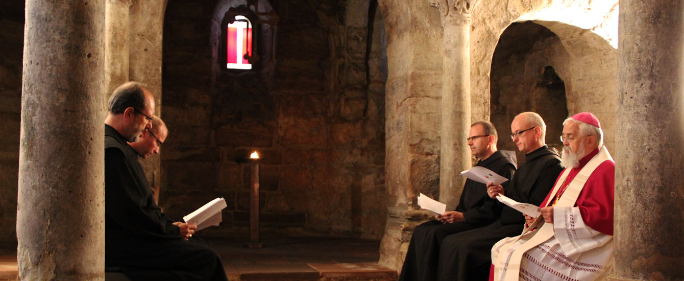 Mönche und Bischof beten in der Krypta die Vesper.