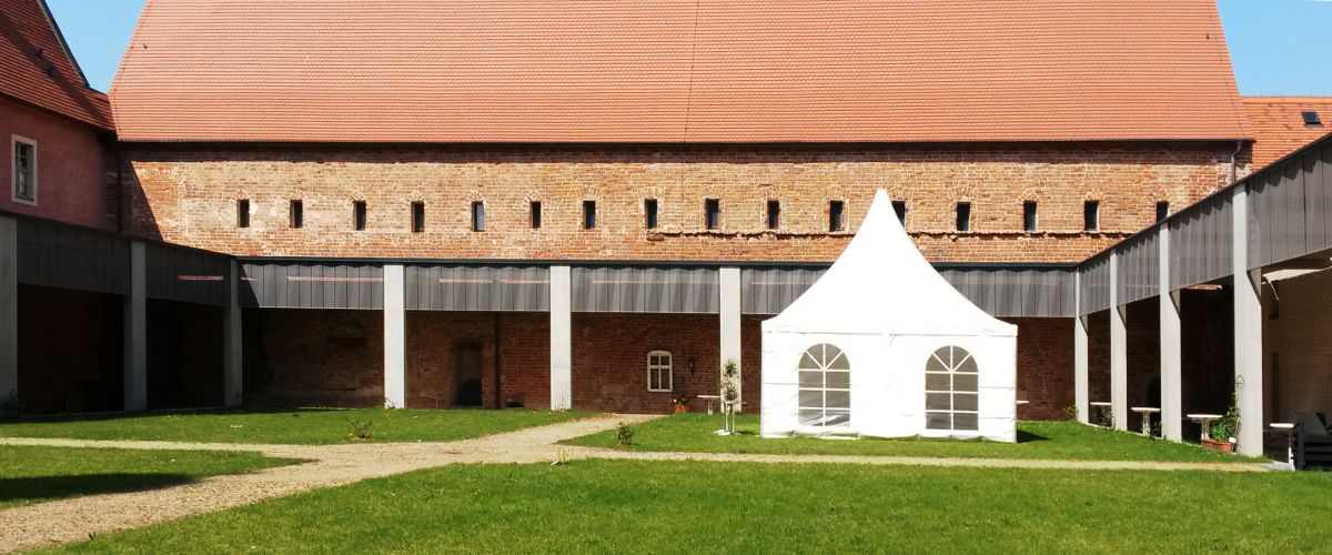 Blick durch den Garten des Kreuzgangs auf das Gemaeuer