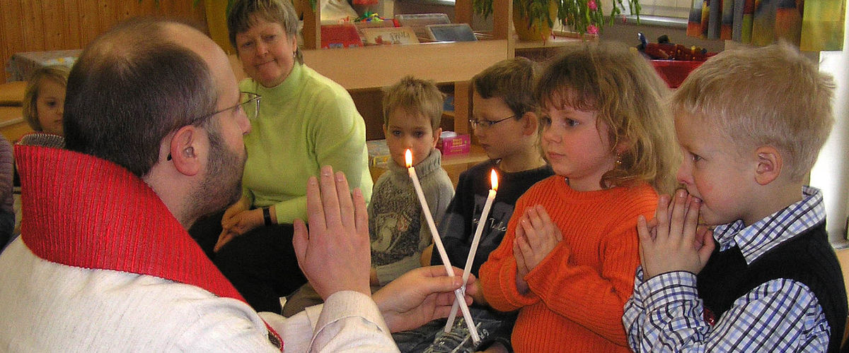 Priester spendet Kindern den Blasiussegen